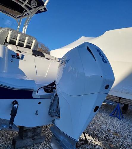 Slide: The Image of 2023 Wellcraft 222 Fisherman boat with powerful outboard motor, parked on gravel. - 1