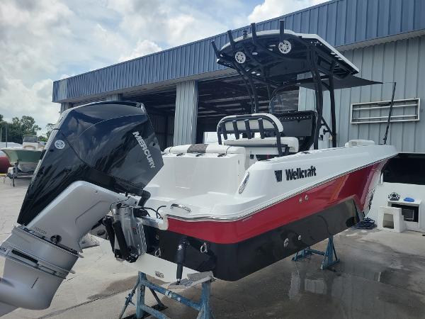 Slide: The Image of 2024 Wellcraft 222 Fisherman boat with Mercury outboard motor in a marina. - 2