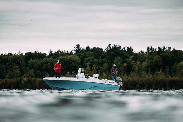 Slide: The Image of 2024 Wellcraft 222 Fisherman boat on a lake with two people fishing. - 44