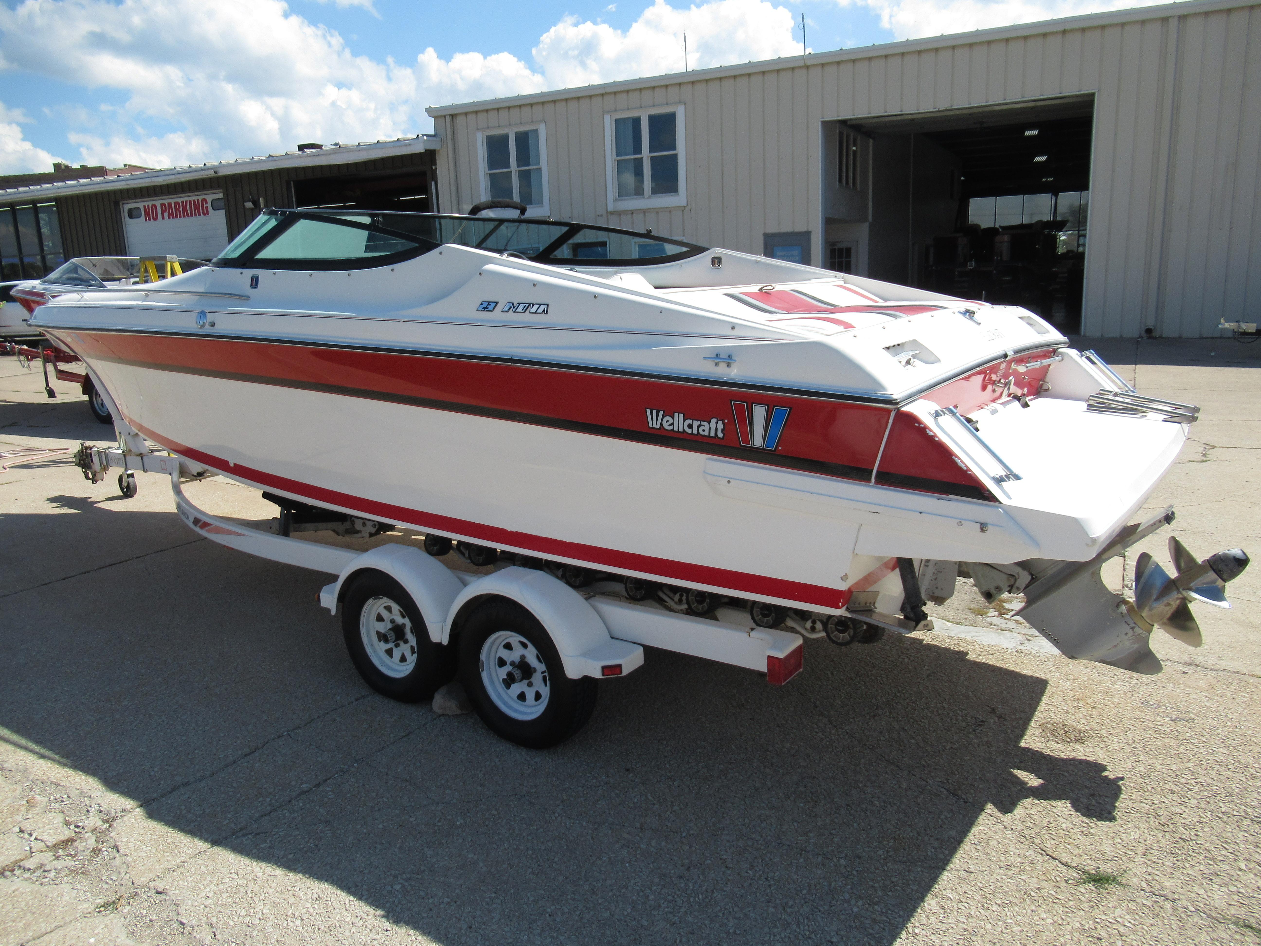 Slide: The Image of 1990 Wellcraft 23 NOVA boat on a trailer outside a warehouse. - 14