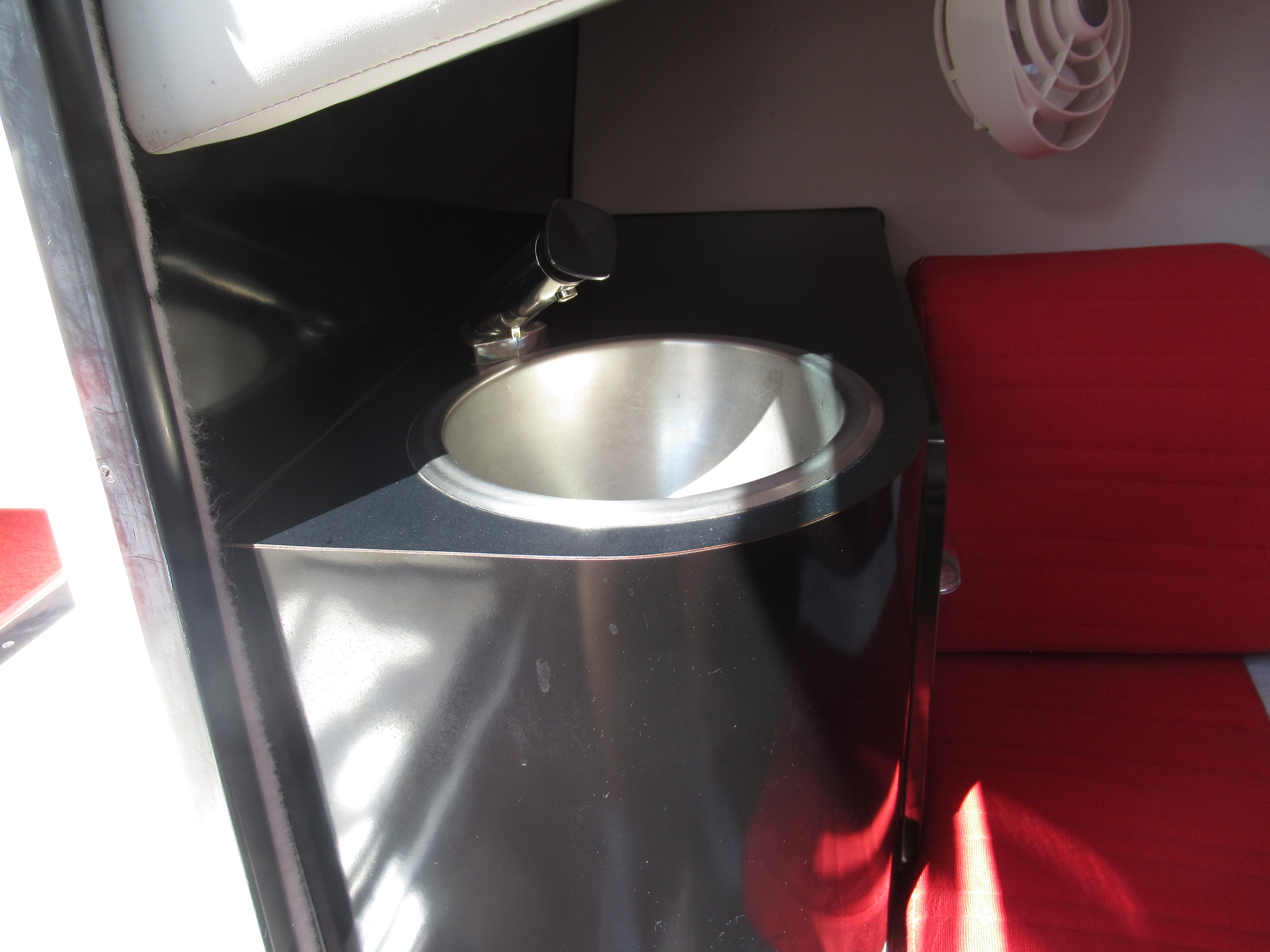 Slide: The Image of Interior sink and seating of 1990 Wellcraft 23 NOVA boat with red upholstery. - 21