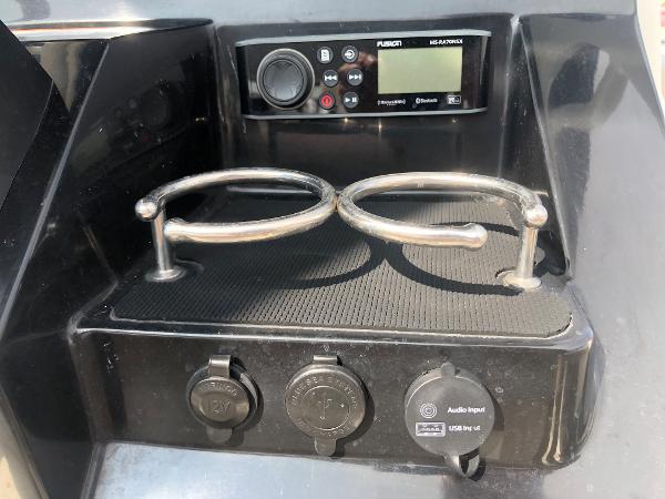 Slide: The Image of Control panel and cup holders on a 2019 Wellcraft 242 Fisherman boat. - 22