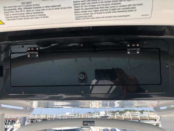 Slide: The Image of 2019 Wellcraft 242 Fisherman boat console with storage compartment and safety instructions. - 23