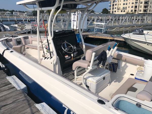Slide: The Image of 2019 Wellcraft 242 Fisherman boat docked at marina, featuring spacious seating and modern controls. - 6