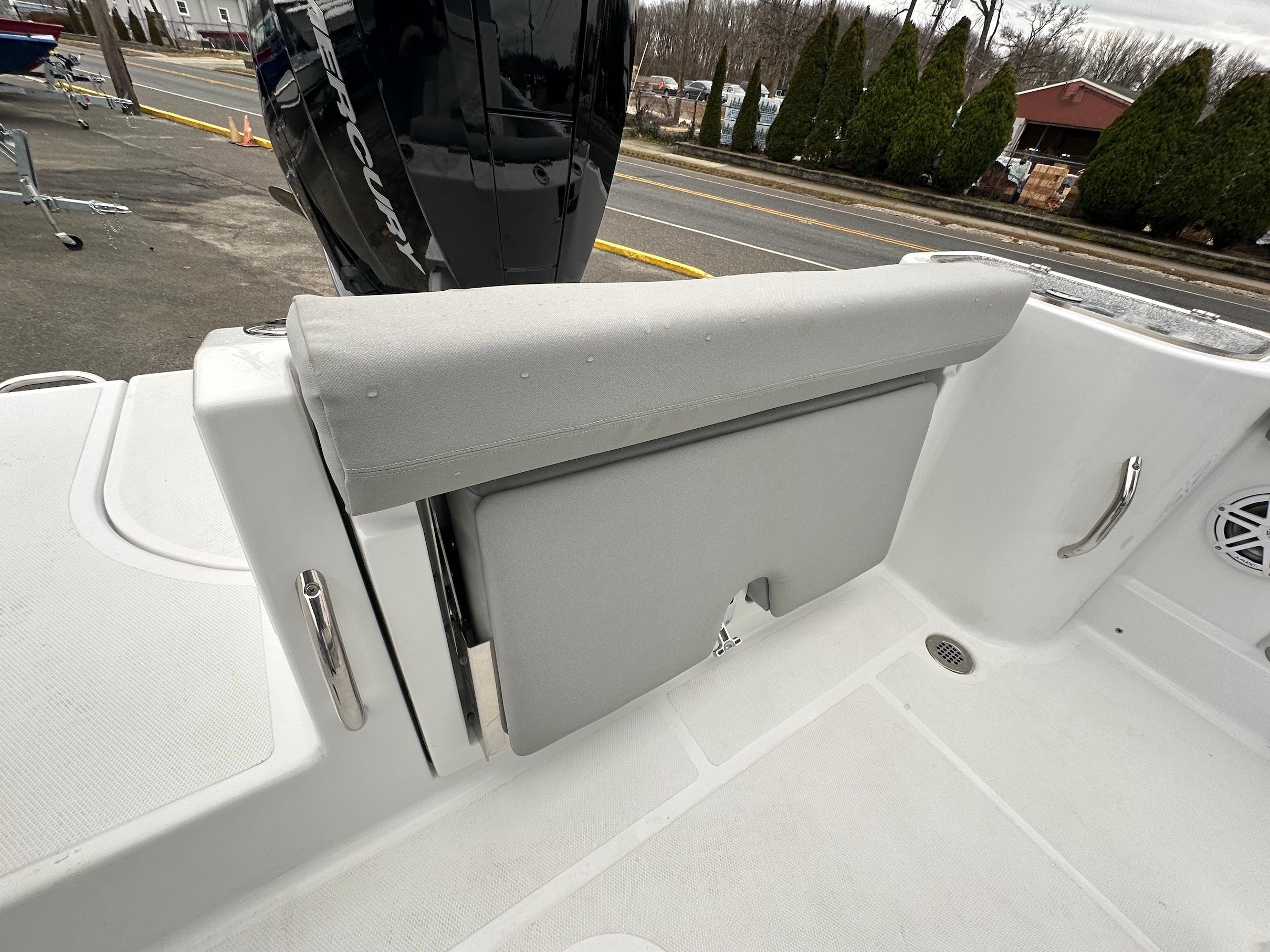 Slide: The Image of 2024 Wellcraft 243 Fisherman boat interior with Mercury engine, featuring cushioned seating and stainless steel handles. - 11