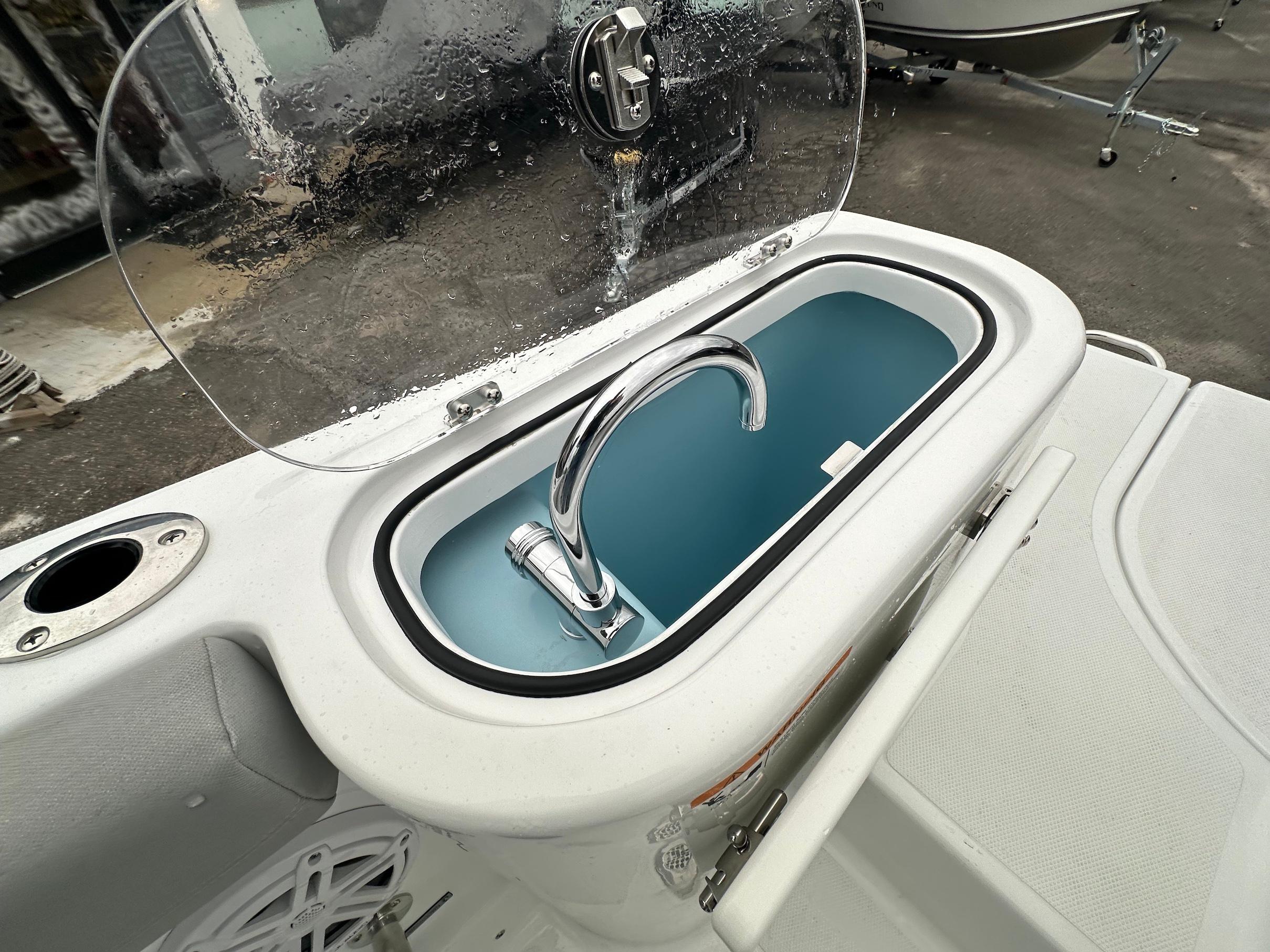 Slide: The Image of 2024 Wellcraft 243 Fisherman boat sink with chrome faucet and transparent cover. - 14