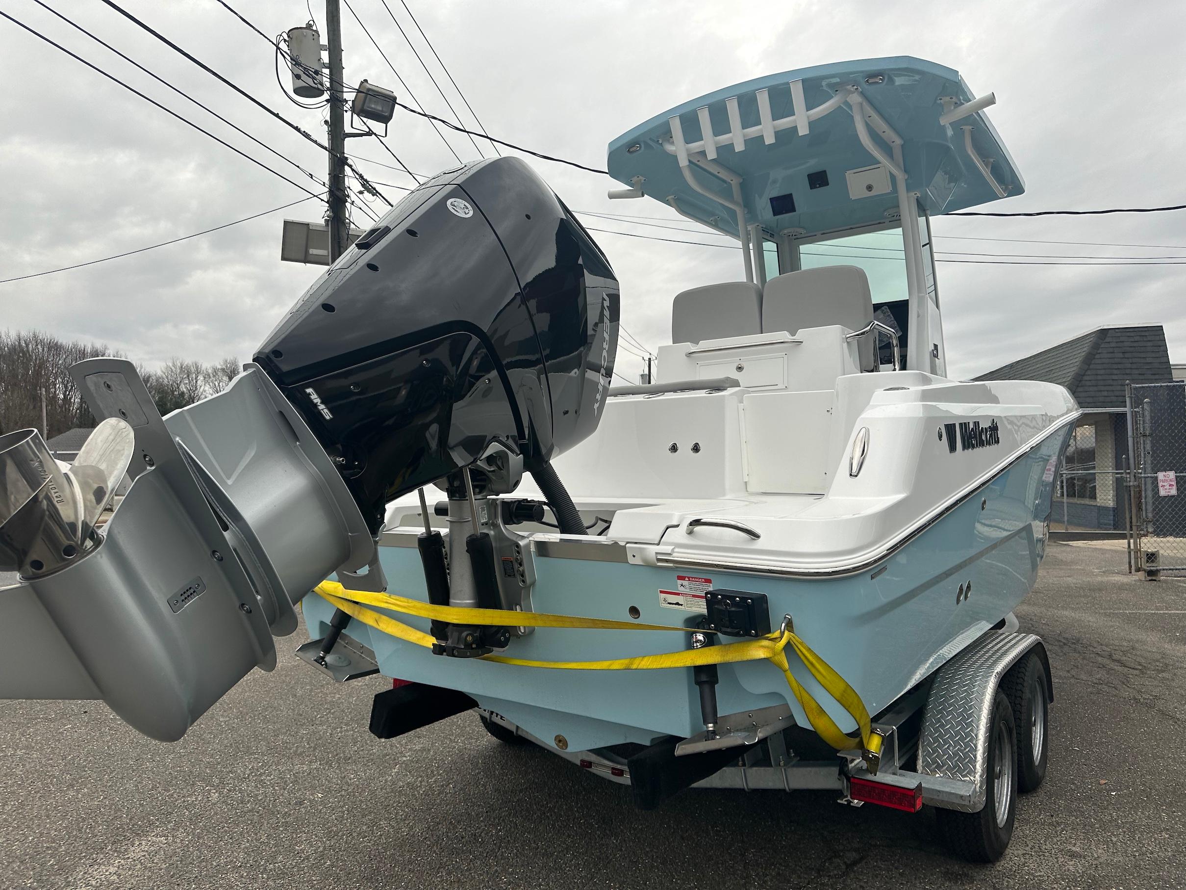 Slide: The Image of 2024 Wellcraft 243 Fisherman boat on trailer, featuring a powerful outboard motor. - 2