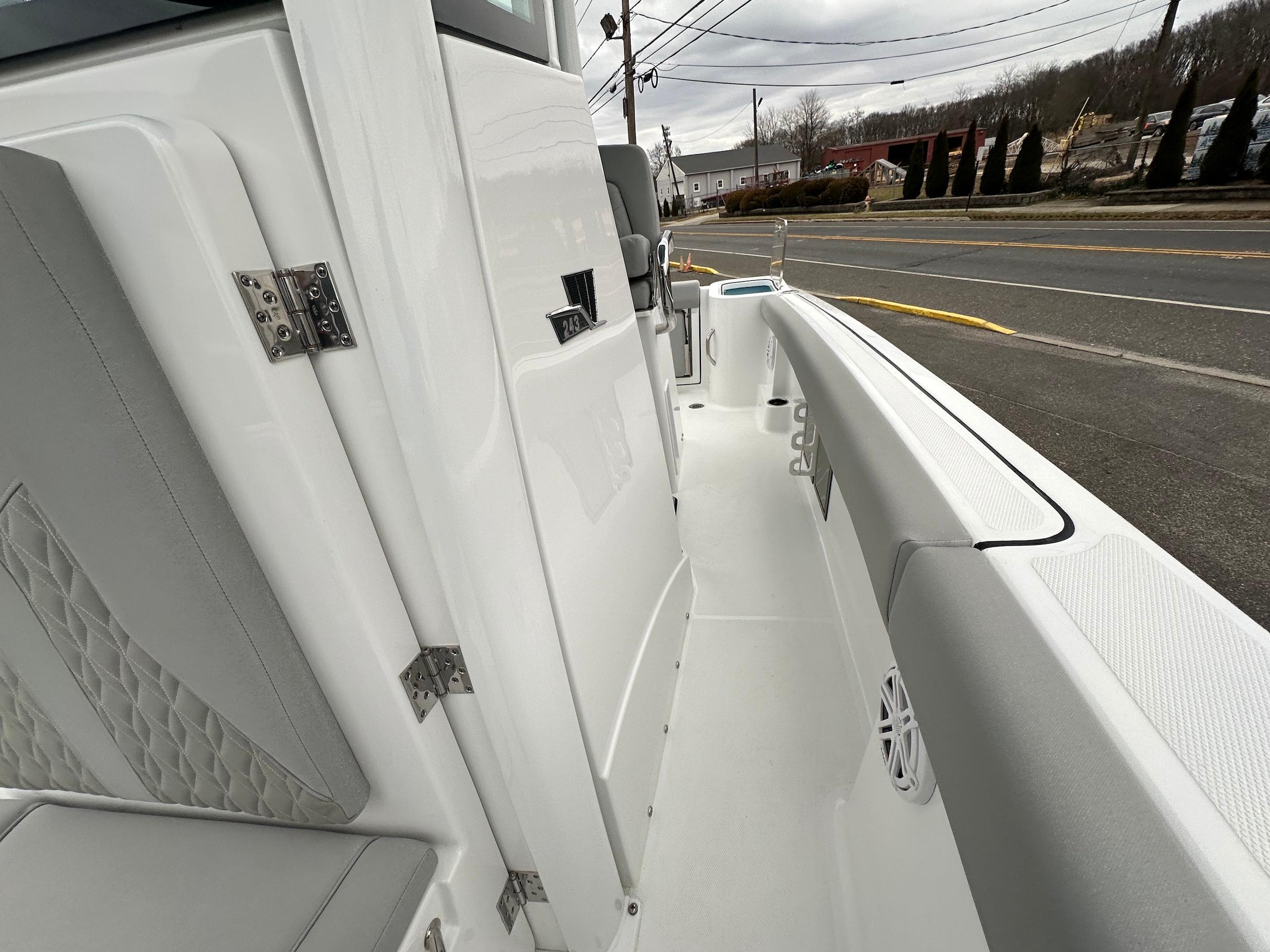 Slide: The Image of 2024 Wellcraft 243 Fisherman boat interior, featuring sleek white and gray design with cushioned seating. - 29