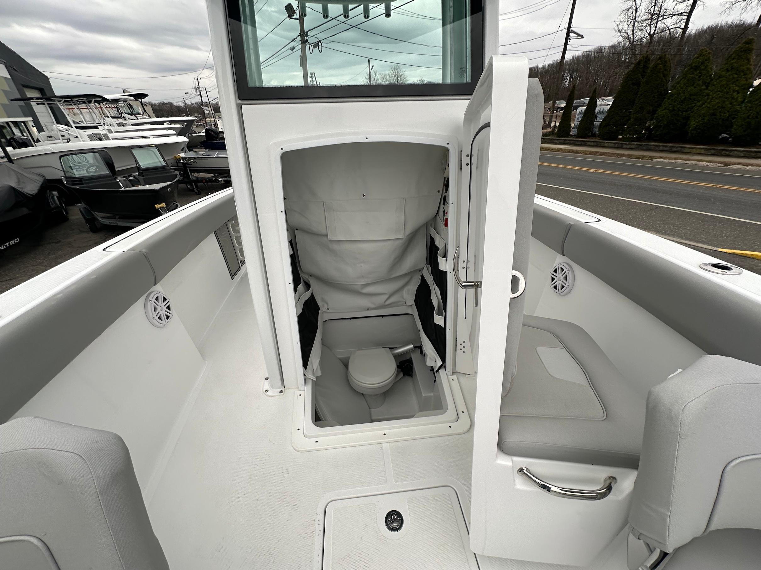 Slide: The Image of 2024 Wellcraft 243 Fisherman boat interior with open cabin door and seating area. - 30