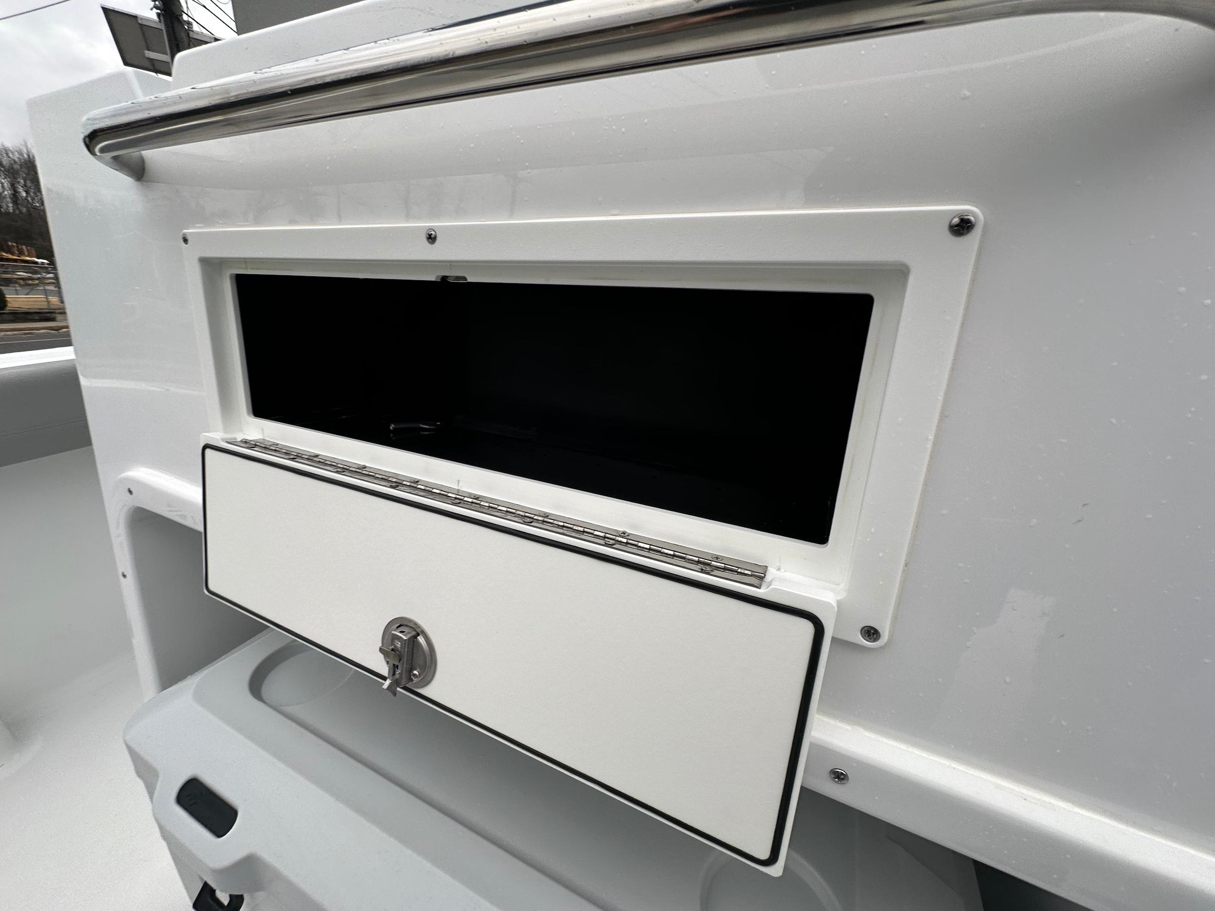 Slide: The Image of 2024 Wellcraft 243 Fisherman boat storage compartment with open hatch and lock. - 8