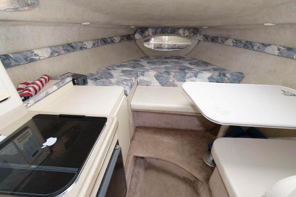 Slide: The Image of 1998 Wellcraft 260 SE cabin interior with bed, table, and kitchenette. - 9
