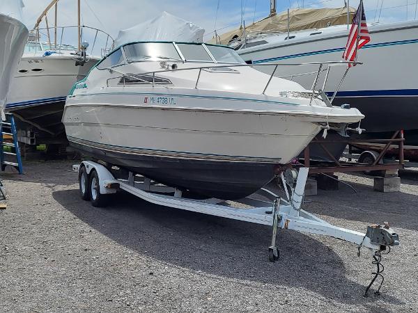 Slide: The Image of 1995 Wellcraft 26 Exel SE boat on a trailer in a marina. - 0