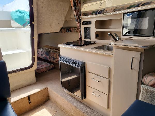 Slide: The Image of Interior of 1995 Wellcraft 26 Exel SE boat with kitchenette and seating area. - 10