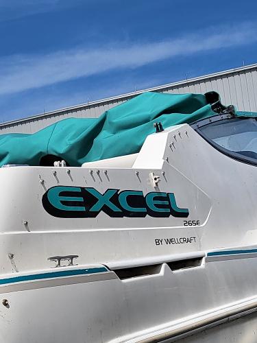 Slide: The Image of 1995 Wellcraft 26 Exel SE boat with teal cover and blue sky background. - 13