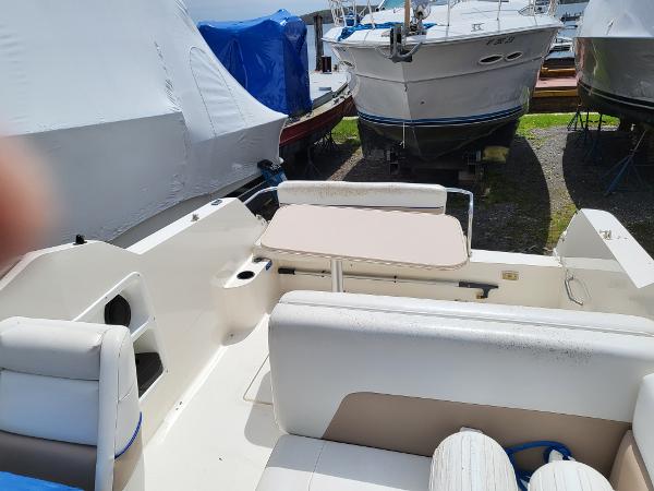 Slide: The Image of 1995 Wellcraft 26 Exel SE boat interior with seating and table, docked among other boats. - 4