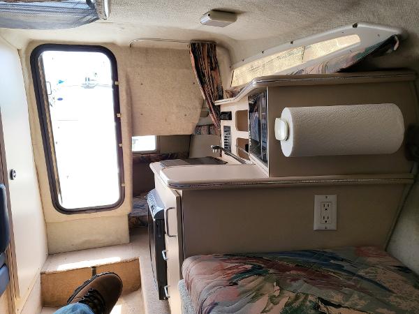 Slide: The Image of Interior of a 1995 Wellcraft 26 Exel SE boat with kitchenette and seating area. - 8