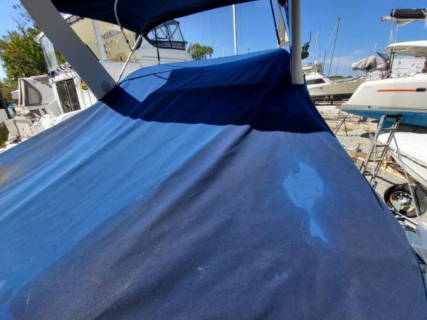 Slide: The Image of 1997 Wellcraft 2800 Martinique boat with blue canvas cover in a marina. - 2
