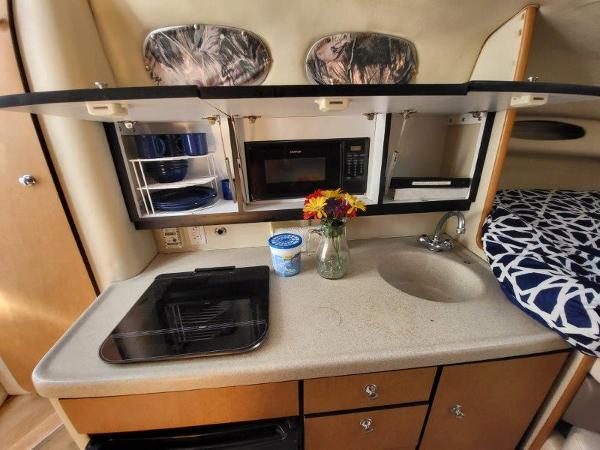 Slide: The Image of 1997 Wellcraft 2800 Martinique boat kitchen with microwave, sink, and stove. - 21