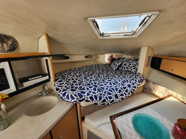 Slide: The Image of 1997 Wellcraft 2800 Martinique cabin interior with bed, sink, and dining area. - 22