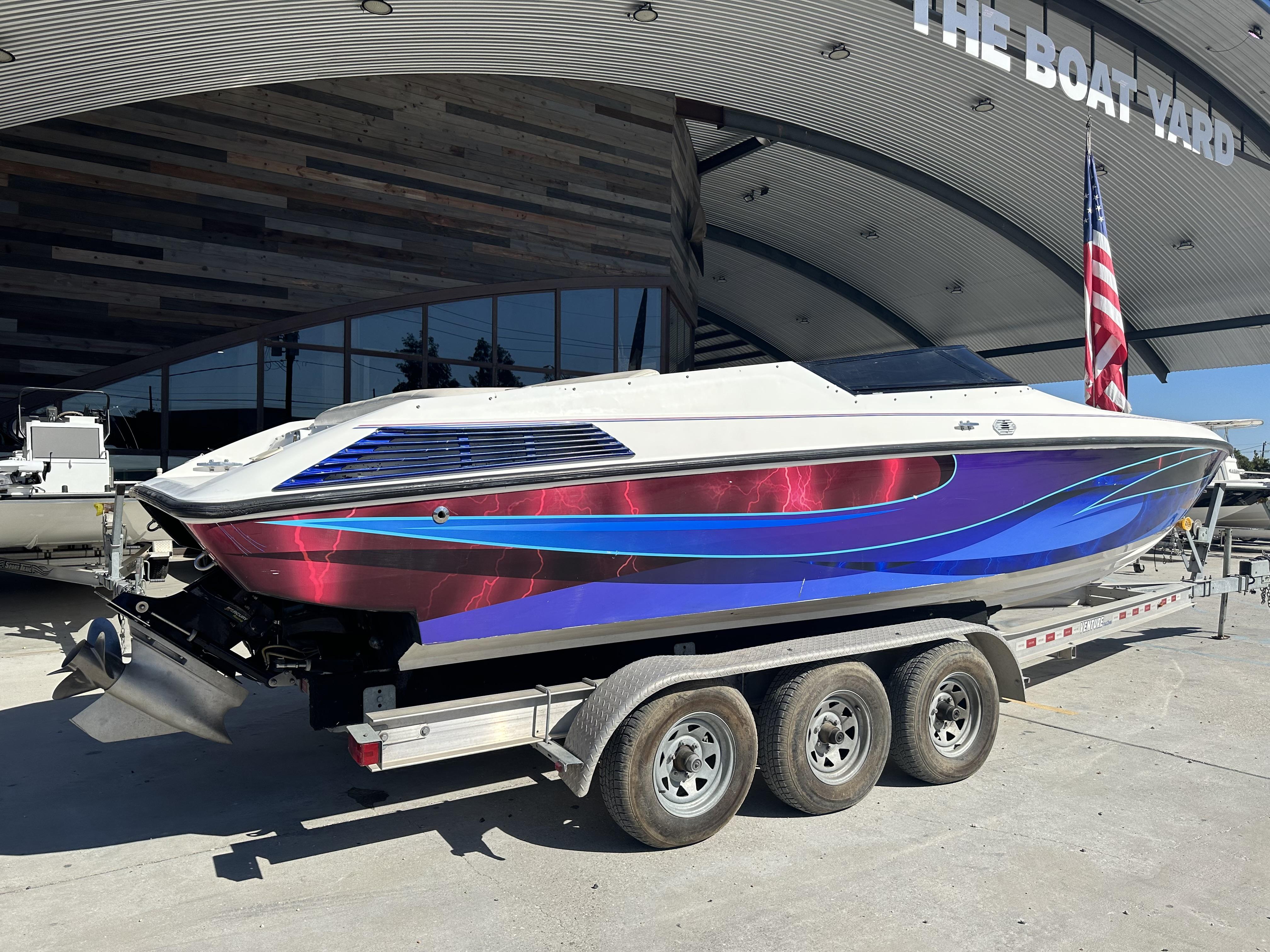 Slide: The Image of 1994 Wellcraft 2900 Sportboat with vibrant graphics on a trailer at The Boat Yard. - 1