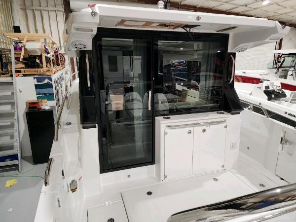 Slide: The Image of 2024 Wellcraft 355 Commuter boat interior with sliding glass door and storage cabinets. - 12