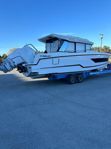 Slide: The Image of 2024 Wellcraft 355 Commuter boat on a trailer, side view. - 2