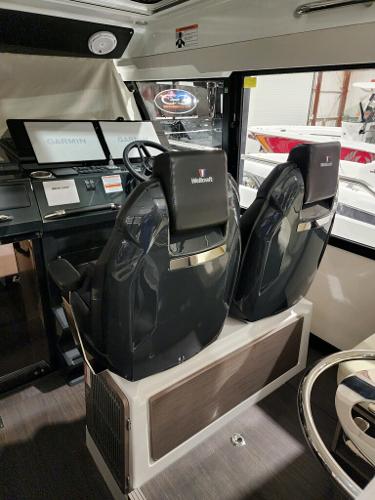 Slide: The Image of 2024 Wellcraft 355 Commuter boat interior with dual captain seats and navigation screens. - 27