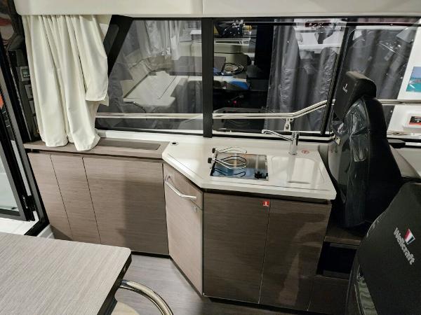 Slide: The Image of 2024 Wellcraft 355 Commuter interior with modern cabinetry and sink. - 31