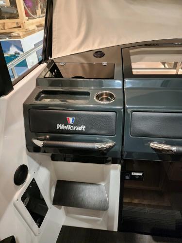 Slide: The Image of 2024 Wellcraft 355 Commuter boat interior dashboard with storage compartments and cup holder. - 36