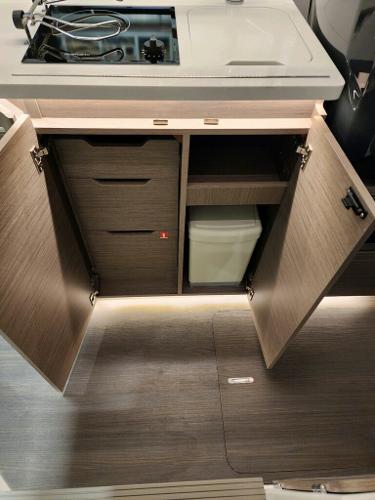 Slide: The Image of 2024 Wellcraft 355 Commuter kitchen area with open cabinets and modern design. - 50