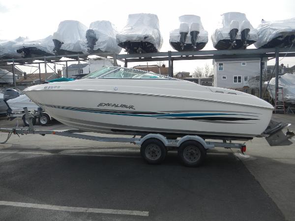 Slide: The Image of 2000 Wellcraft EXCALIBUR boat on a trailer in a marina storage area. - 0