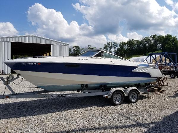 Slide: The Image of 1988 Wellcraft 23 NOVA XL boat on a trailer in a gravel lot. - 0
