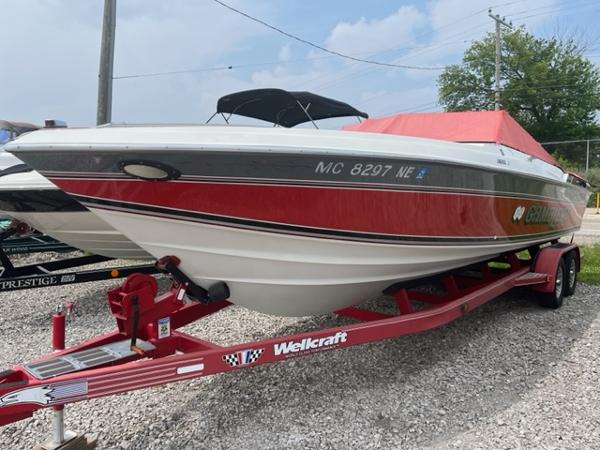 Slide: The Image of 1987 Wellcraft Nova Spyder 26 boat on a red trailer in a gravel lot. - 1