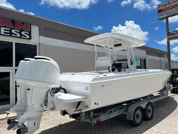 Slide: The Image of 1979 Wellcraft Scarab Sport 302 boat on trailer, white exterior, twin outboard engines. - 2
