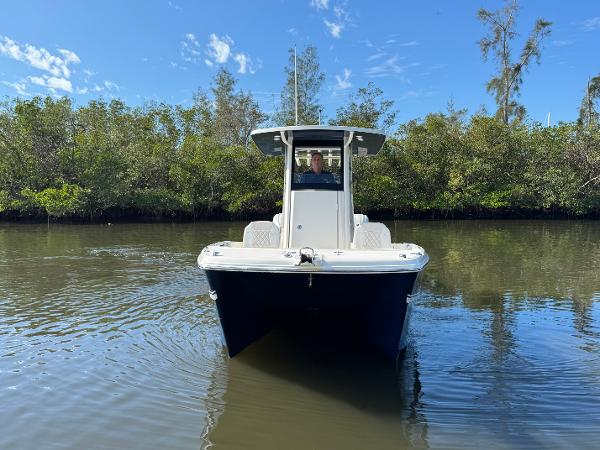 Slide: The Image of 2025 World Cat 235 CC boat navigating calm waters, surrounded by lush greenery. - 3