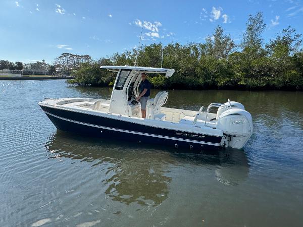 Slide: The Image of 2025 World Cat 235 CC boat on calm water, surrounded by lush greenery. - 5