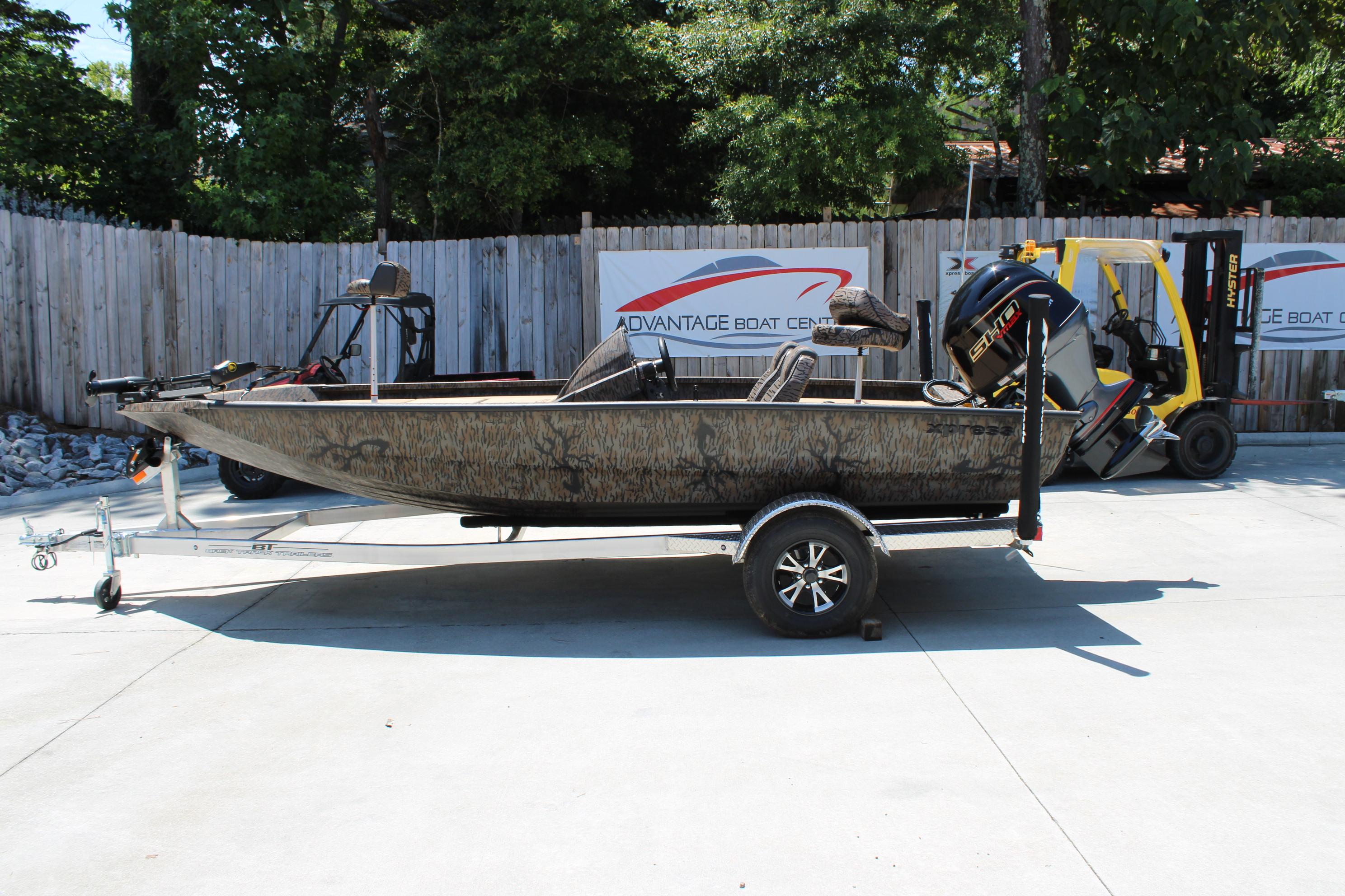 Slide: The Image of 2026 Xpress H18 boat on trailer, parked outdoors near Advantage Boat Center. - 1