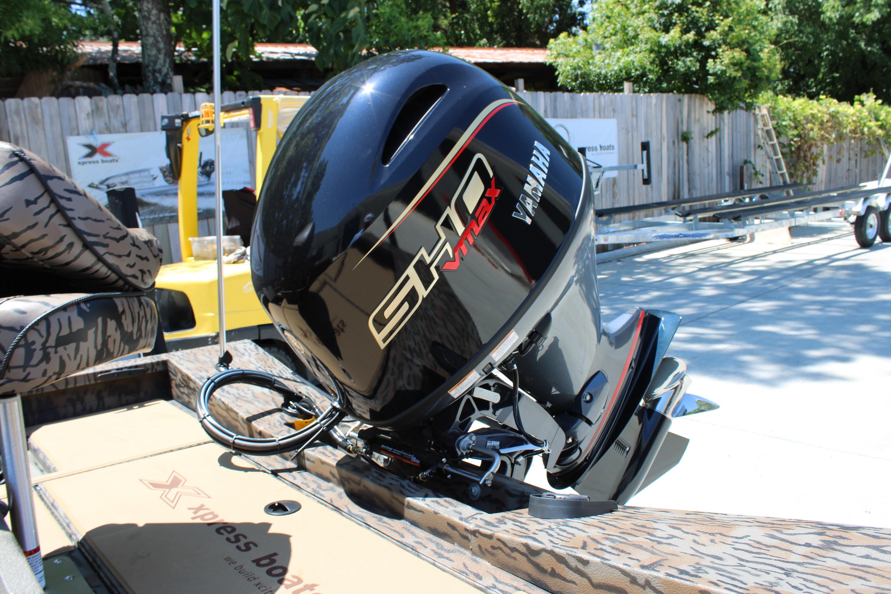 Slide: The Image of 2026 Xpress H18 boat with Yamaha VMAX outboard motor, parked outdoors. - 16