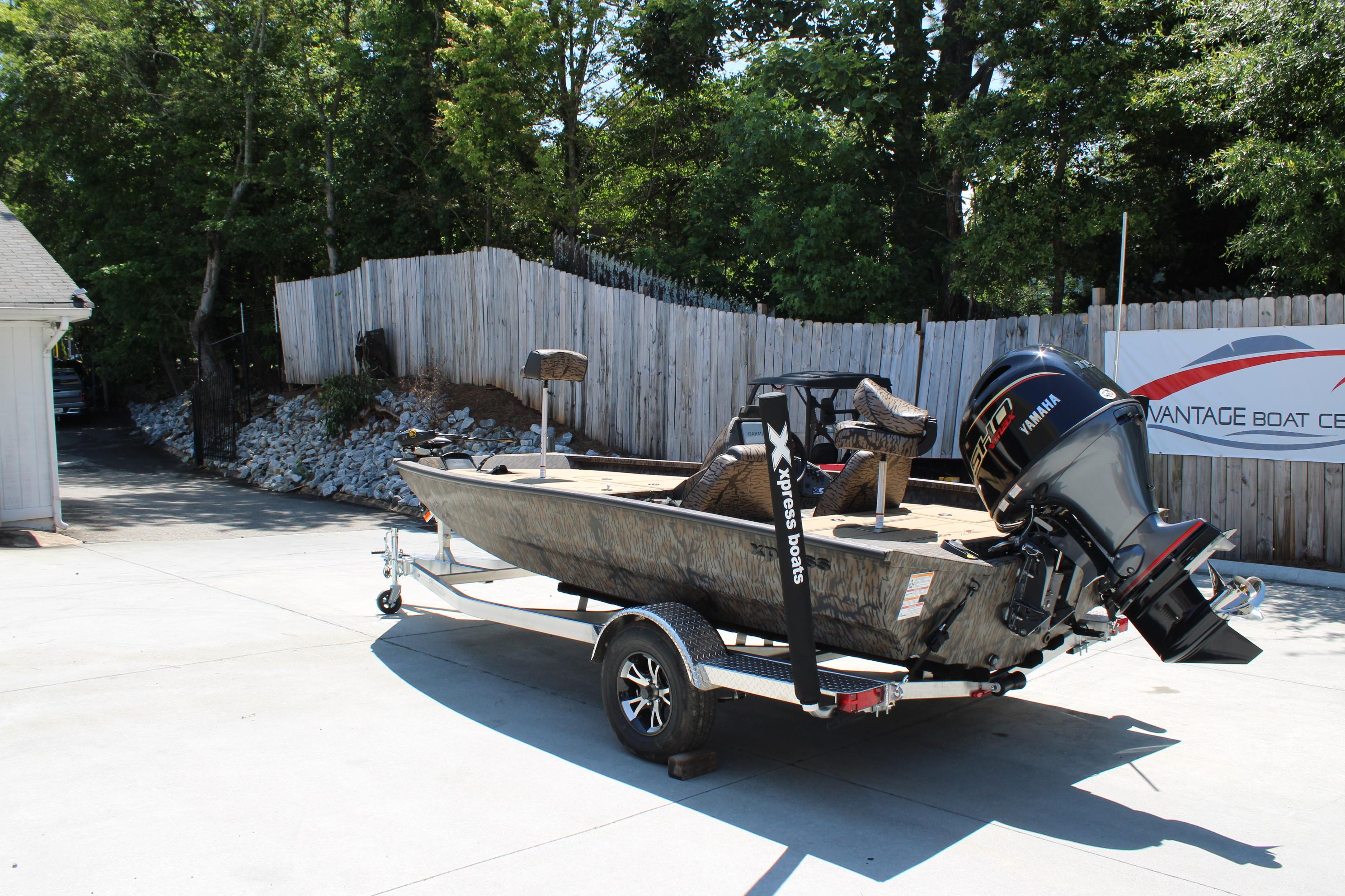 Slide: The Image of 2026 Xpress H18 boat on trailer with Yamaha outboard motor, parked outdoors. - 2