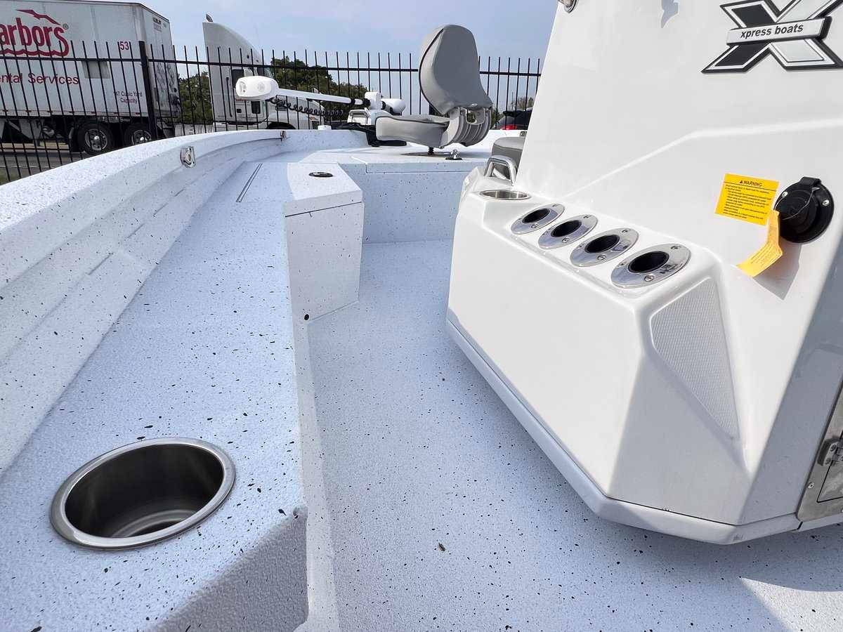 Slide: The Image of 2024 Xpress H20B HYPER-LIFT BAY boat interior with rod holders and cup holder. - 5