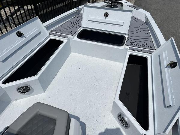 Slide: The Image of 2025 Xpress H22B boat with open storage compartments and SeaDek flooring. - 6