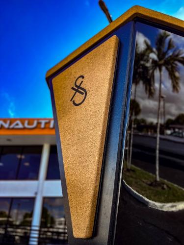 Slide: The Image of Close-up of 2023 X Shore Eelex 8000 boat emblem with palm trees and building in background. - 13