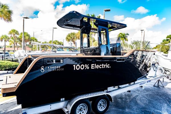 Slide: The Image of 2023 X Shore Eelex 8000 electric boat on a trailer under a bright blue sky. - 20