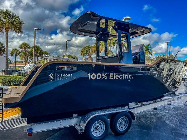 Slide: The Image of 2023 X Shore Eelex 8000 electric boat on trailer under blue sky. - 3