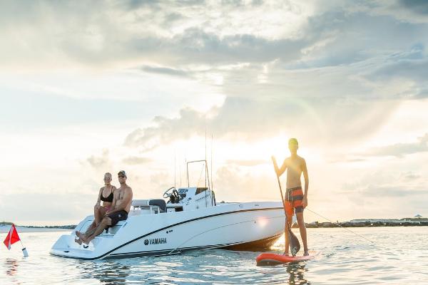 Slide: The Image of 2023 Yamaha Boats 210 FSH with people enjoying water activities at sunset. - 5