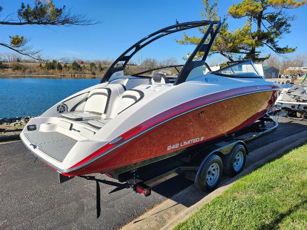Slide: The Image of 2016 Yamaha Boats 242 Limited S on trailer by a lake. - 1