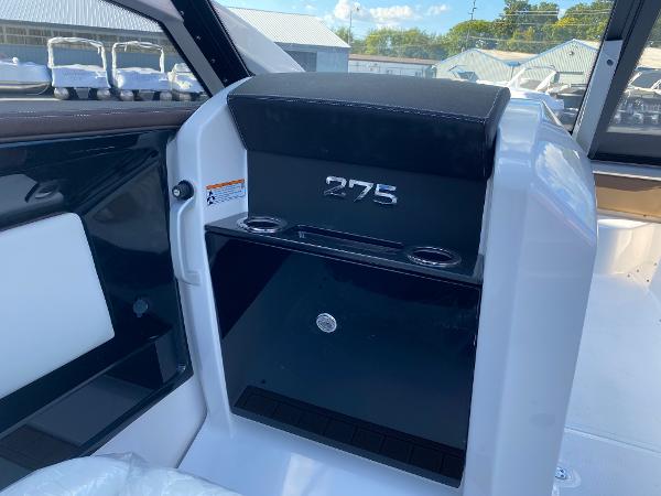 Slide: The Image of 2023 Yamaha Boats 275SE interior console with cup holders and storage compartment. - 7