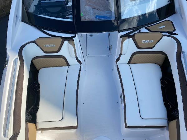 Slide: The Image of 2023 Yamaha Boats 275SE interior seating area with white and tan upholstery. - 8