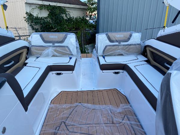 Slide: The Image of 2023 Yamaha Boats 275SE interior with cushioned seating and teak flooring. - 9