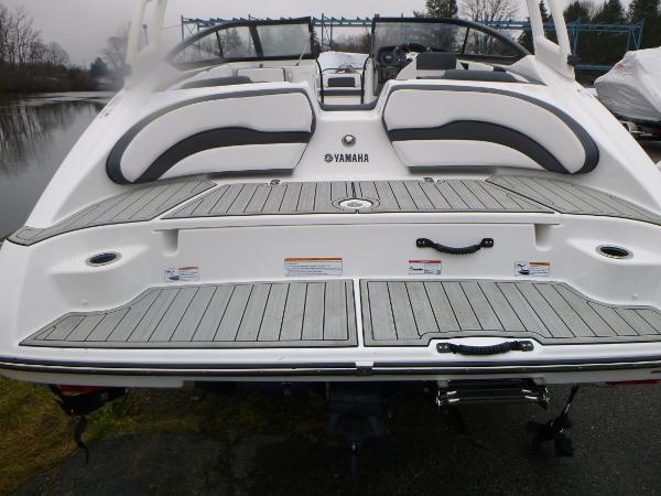 Slide: The Image of 2024 Yamaha Boats AR195 rear view with spacious deck and seating. - 35